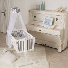 a white baby crib next to a piano