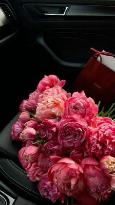 a bouquet of pink flowers sitting in the passenger seat of a car