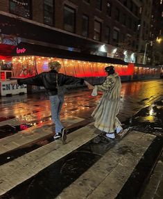 two people walking down the street in the rain