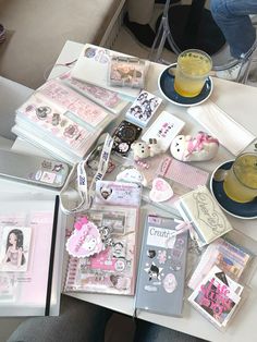 a table topped with lots of cards and other items next to a glass of orange juice