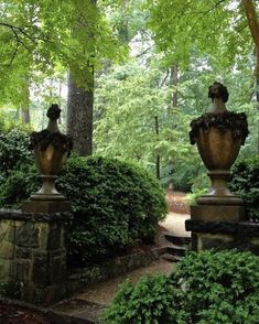 two large urns sitting in the middle of a garden