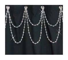 a black background with some silver chains hanging from it's sides and beads on each side