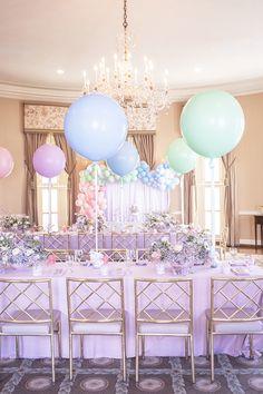 a table set up with balloons and flowers