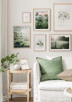 a living room filled with white furniture and pictures on the wall above it's couch