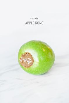 an apple that has been cut in half and is sitting on a white surface with the words edible apple kong above it