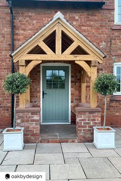 the front entrance to a house with two planters on either side and an entry door