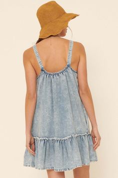 Acid washed denim mini dress. Side pockets. Scoop neckline. Adjustable shoulder straps with double ring buckles. Sleeveless. Low scoop back. Ruffled, drop-waist hem with raw edge. A-line babydoll silhouette. Thigh length. Relaxed fit. 100% Cotton. Imported. Designed in LA. Model wears size S. Denim Mini Dress, Double Ring, Washed Denim, Denim Mini, Drop Waist, Acid Wash, Denim Blue, Raw Edge, Denim Wash