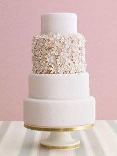 a three tiered cake with white flowers on top