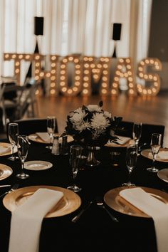 a black table with white and gold place settings