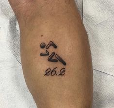 a man's leg with a tattoo on it that reads 2052 and has an image of a running man