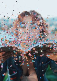 a woman reading a book while covered in confetti