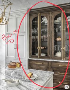 a kitchen with marble counter tops and gold trim on the cabinet doors is circled by a red circle