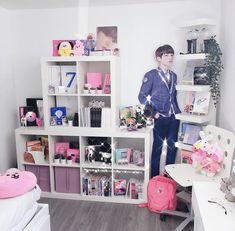 a person standing in front of a book shelf filled with books and other stuff items