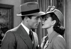 a man in a suit and hat kissing a woman