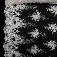 white lace on black fabric with snowflakes in the center and sequins at the bottom