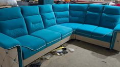 a blue couch sitting on top of a floor next to a pile of shoes