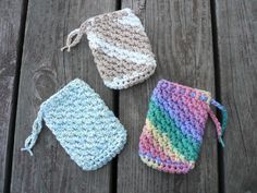 three crocheted bags sitting on top of a wooden table