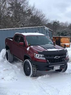 a red truck is parked in the snow