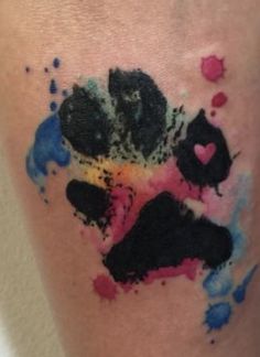 a person with a tattoo on their leg that has paint splatters all over it