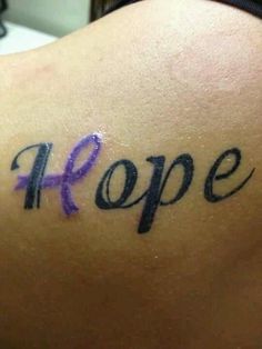 the word hope painted on someone's back shoulder with purple ribbon in black ink