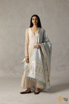 "\nReminiscent of a bygone era, this handloom\u00a0dupatta is patterned with delicate\u00a0peacock\u00a0bootis\u00a0and Rani or queen figures\u00a0along the borders in Banarasi Baluchari artistry. A timeless drape of resplendent silk and regal zari work.\u00a0\n\n\nColor\u00a0- A\u00a0beautiful shade of\u00a0Grey\n\nTechnique\u00a0- Classic handwoven Banarasi art passed down through generations of weavers.\n\nFabric\u00a0- Soft as butter, pure Katan silk\n\nSpeciality\u00a0- A unique Rani motif which adds a touch of royalty to the dupatta with beautiful Baluchari bootas. The incredibly detailed craftsmanship of making figure motifs is a rarer hand-weaving skill.\u00a0\n\nTilfi Promise\u00a0- Pure. Handloom. Banaras.\u00a0\n\n\u00a0\nThis product is handwoven and there might be slight irreg Katan Silk, Zari Work, Bygone Era, Unique Charms, Shades Of Grey, Chic Outfits, Borders, Hand Weaving, Royalty