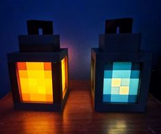 two lit cubes sitting on top of a wooden table