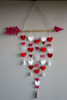 an arrow and heart mobile hanging on the wall