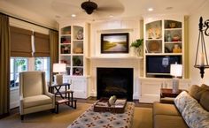 a living room filled with furniture and a fire place next to a tv mounted on a wall