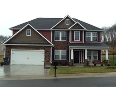 a two story house with brown siding and white trim on the front door is shown