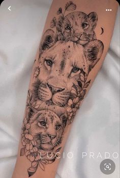 a woman's arm with two lions on it and flowers in the middle of her arm