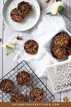 some cookies are on a wire rack next to a white plate with flowers and plates