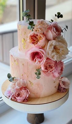 a three tiered cake with pink flowers on top