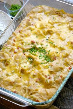 a casserole dish with meat and vegetables in it sitting on a wooden table