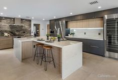 a modern kitchen with marble counter tops and stainless steel appliances