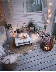 a porch decorated with candles, flowers and other decorating items on the wooden deck