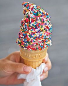 someone holding an ice cream cone with sprinkles