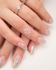 a woman's manicured nails with white flowers on the tip and silver tips