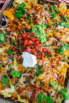 an enchilada is topped with sour cream and cilantro, tortilla chips