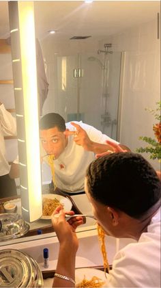 a man taking a selfie in front of a mirror with food on the counter