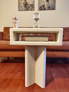 a table with a book on it in the middle of a living room next to a couch