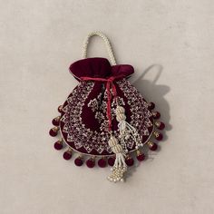 Introducing our exquisite Velvet Elegance Potli Bag - a perfect blend of sophistication and craftsmanship. This opulent bag is crafted from premium velvet fabric, ensuring a touch of luxury in every detail. Hand-embroidered with intricate patterns on one side, this potli bag radiates elegance. The beaded strap adds a glamorous touch, providing both comfort and style. Adorning the bag is a beautiful latkan featuring a beaded tassel, enhancing its charm. The meticulous embroidery work showcases th Elegant Rectangular Potli Bag For Everyday Use, Elegant Festive Pouch With Latkans, Elegant Festival Pouch With Latkans, Traditional Evening Bag With Latkans, Traditional Evening Pouch Bag, Luxury Embroidered Bag As Gift, Luxury Embroidered Bags As Gifts, Luxury Embroidered Bag For Gifts, Handmade Pouch For Formal Festive Occasions