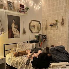 a man laying on top of a bed in a bedroom next to a book shelf