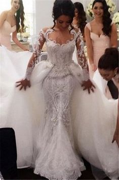 a woman in a wedding dress standing next to other women