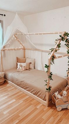 a white canopy bed in a room with wood floors and wooden flooring on the walls