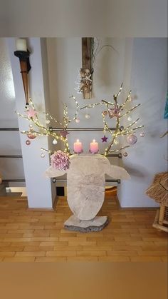 a vase with some candles in it sitting on a wooden floor next to a wall