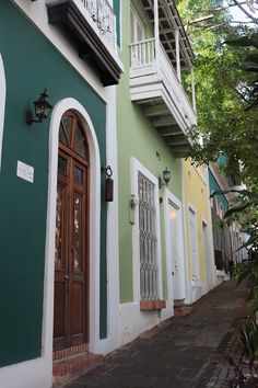 a building with green and white paint on the outside, and brown doors in front