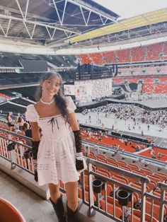 a woman standing in front of an empty stadium