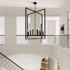 a chandelier hanging from the ceiling in a room with white walls and wooden floors