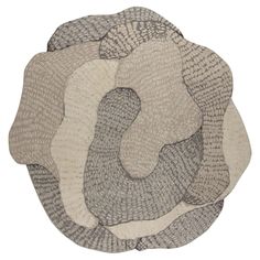 three circular rugs on top of each other in various colors and sizes, one is made out of fabric