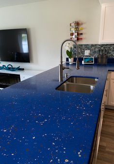 a blue counter top in a kitchen next to a tv